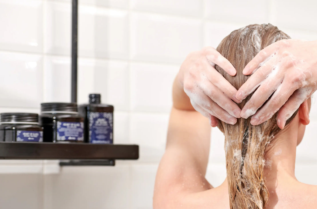 blonde woman washing her hair with Davines Heart of Glass products